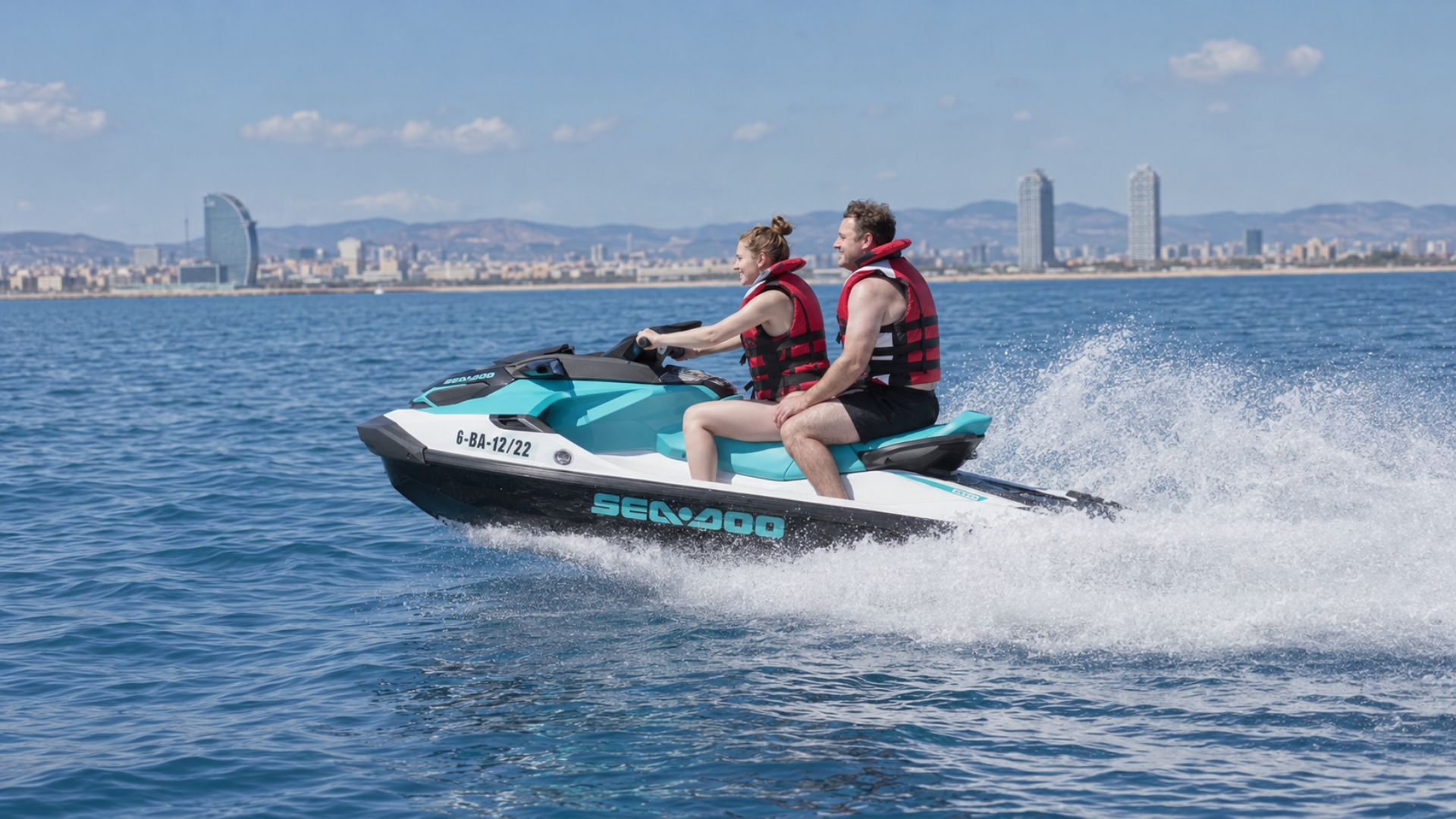 Couple riding a jet ski along the Barcelona coastline